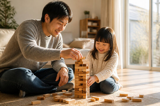 自宅で娘と木製ブロックの遊びを楽しむ日本人の父親