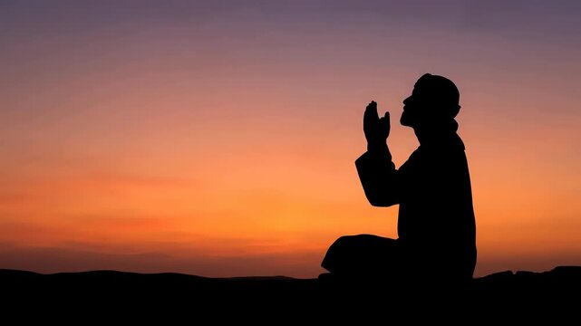 Silhouette of man praying outdoors
