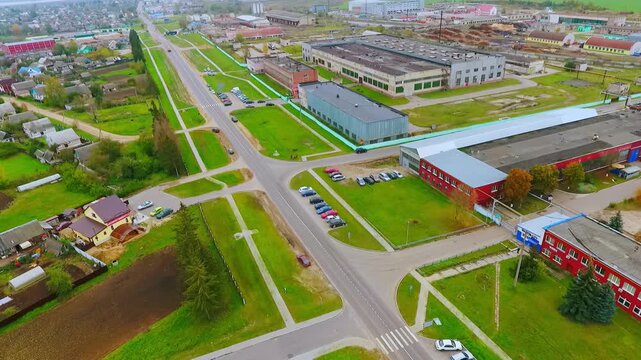 Factory buildings industrial zone aerial. Flyover warehouse parking lot town.