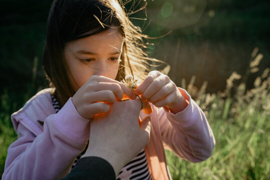 Mother's point of view of her young loving daughter placing a ring made from a clover wildflower on her finger in natural sunlight outdoors; Melbourne, Victoria, Australia