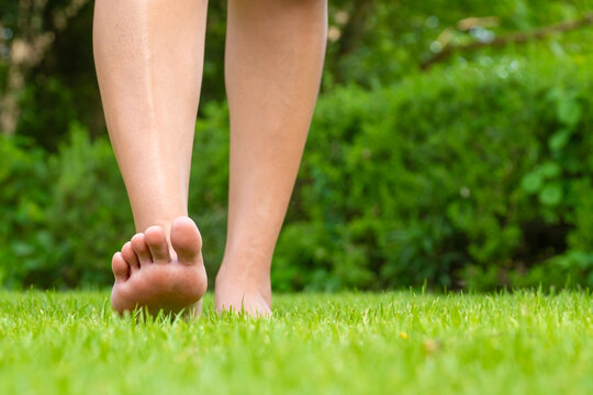 Leg of woman is on the ground. She is about to walk down the grass to exercise in the morning. Health and Relaxation Concepts	