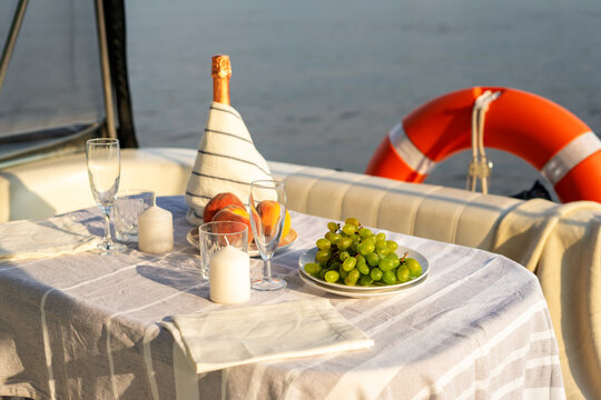 Romantic breakfast or dinner on a motor yacht. Hard sunlight.