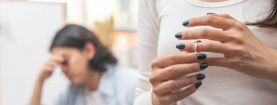 Relationship problem concept. Wife taking off marriage ring after husband cheating on her
