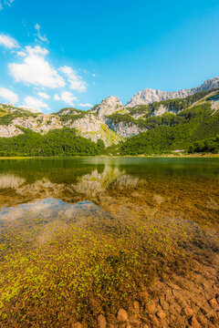 Alpine hiking trail from Prijevor in Bosnia to Trnovacko Lake in Montenegro, dramatic Dinaric Alps in Sutjeska park landscapes and crystal clear turquoise water.