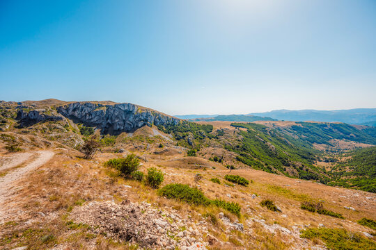 Grand panoramic view from Prutas peak at sunset, overlooking the dramatic limestone ridges and deep valleys of Durmitor National Park, Montenegro.