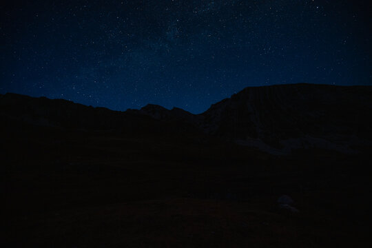 Grand panoramic view from Prutas peak at night with sky, overlooking the dramatic limestone ridges and deep valleys of Durmitor National Park, Montenegro.