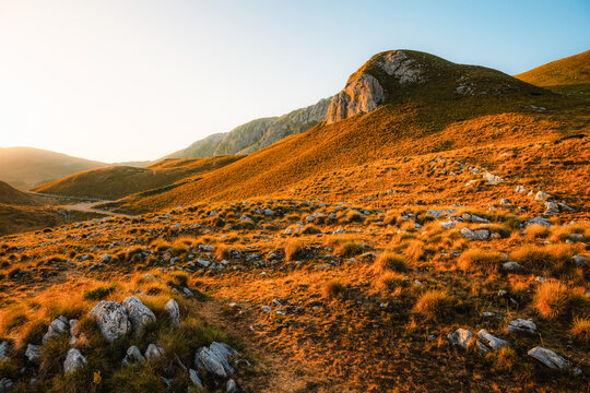 Grand panoramic view from Prutas peak at sunset, overlooking the dramatic limestone ridges and deep valleys of Durmitor National Park, Montenegro.