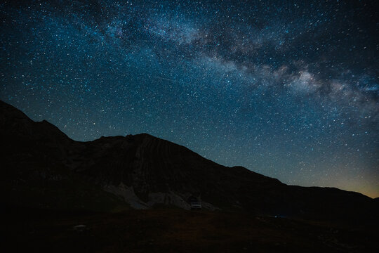 Grand panoramic view from Prutas peak at night with sky, overlooking the dramatic limestone ridges and deep valleys of Durmitor National Park, Montenegro.