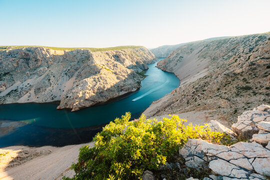 View of the Zrmanja River Canyon in Croatia, with winding turquoise waters cutting through limestone cliffs. A scenic natural wonder popular for kayaking and hiking