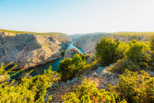 View of the Zrmanja River Canyon in Croatia, with winding turquoise waters cutting through limestone cliffs. A scenic natural wonder popular for kayaking and hiking