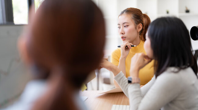 Asian Businesswomen Discussing Work and Thinking in Office Meeting