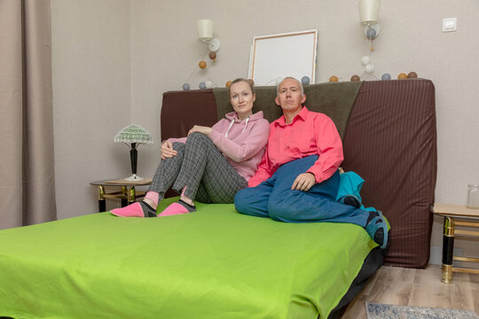 Adult couple sitting together on bed in bedroom. Partners sharing a quiet moment at home. Domestic life and relationship concept. Couple, intimacy and everyday lifestyle