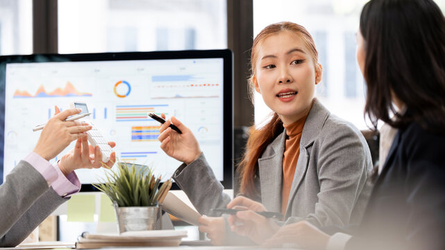 Asian Businesswoman Discussing Strategy and Pointing Pen in Office Meeting