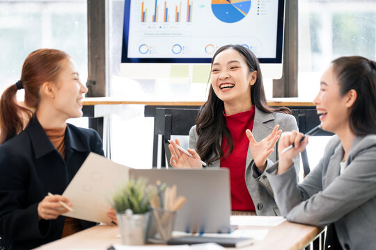 Asian Businesswomen Smiling and Collaborating in Office Meeting