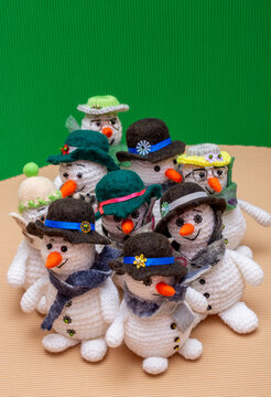 Snowmen crocheted from yarn, set against a colorful background