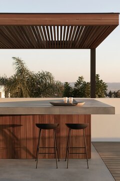 Warm modern terrace with wood pergola, outdoor bar island, stools, plants, and distant landscape