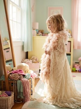Little girl wearing a dress and looking in the mirror at home  