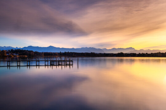 Jetty on Lake Starnberg at sunset with mountain view in Bavaria