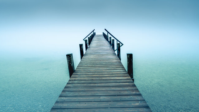 Wooden Jetty extending into foggy Lake Starnberg near Garatshausen