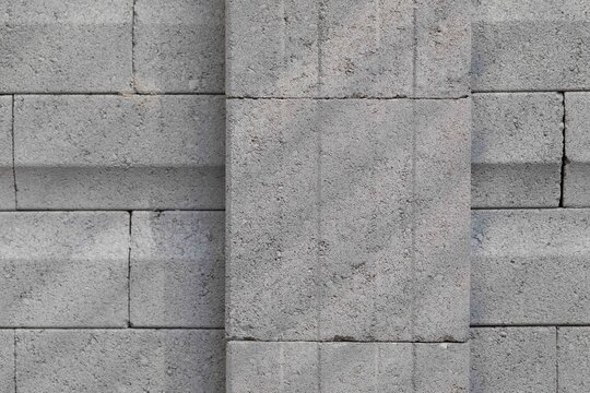 Industrial masonry surface featuring textured cinder blocks and minimalist architectural structure.