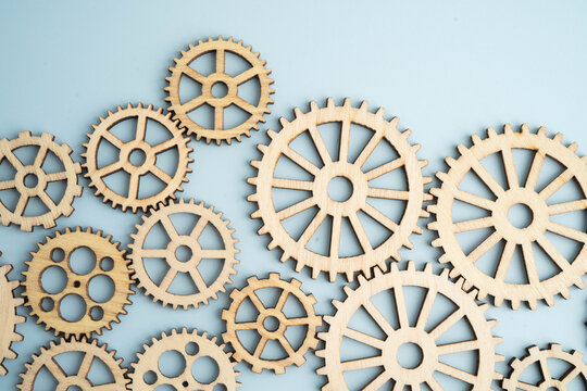 Interlocking wooden gears symbolize teamwork in business.