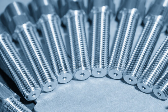 Close-up of a group of threaded end hexagon metal shaft parts in a blue tone scene