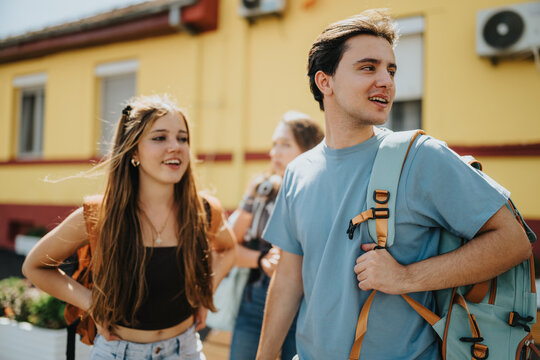 Students and friends talk outside a university campus building, carrying backpacks and enjoying a casual break between classes.