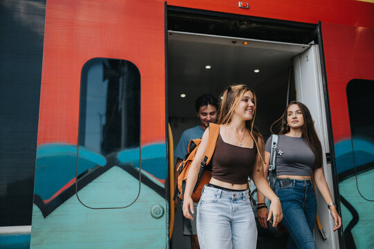Students exit a train with backpacks during campus travel, showing friends commuting by rail for class or adventure.
