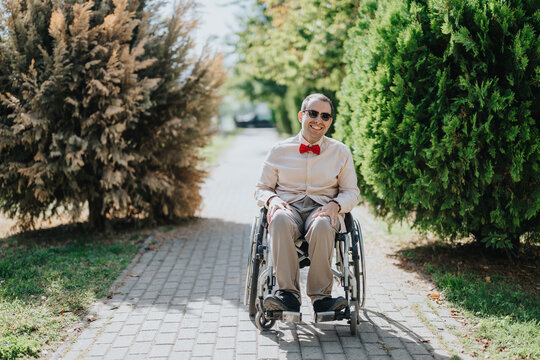 Man uses a wheelchair independently on a park path, representing disability mobility, accessibility and inclusion outdoors.