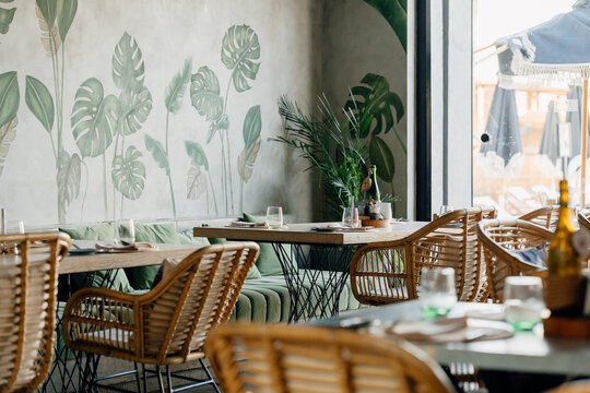 Modern tropical restaurant interior with rattan chairs