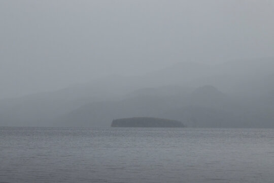 Fog covering mountains behind a lake near Soldotna, Alaska on a summer day.
