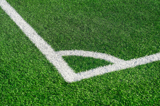 Green artificial turf field with white lines in football soccer sport stadium outdoors. Top view