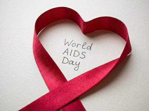 Red ribbon formed into a heart shape with handwritten valentine's day message