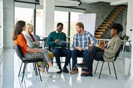 Group psychotherapy. Persons sitting in circle and talking. People meeting. Psychotherapy training, business lecture or conference. Man woman support group. Young businesspeople having a meeting in th