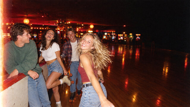 Cheerful Young Friends Roller Skating at Retro Rink