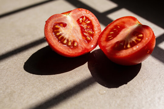 Freshly cut tomato halves on stone in warm sunlight