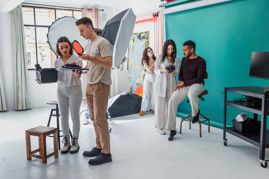 group of young hispanic students of photography in studio, photographers learning in workshop