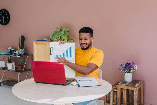 young latino man using laptop in a workplace in Latin America, freelance hispanic male working at creative office