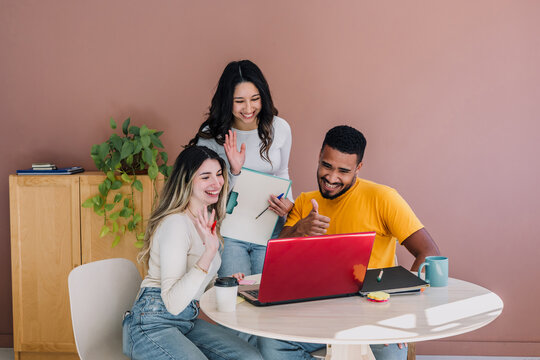 group of young hispanic business people in a video conference call at office in Latin America, Hispanic teamwork or coworkers using laptop at workplace