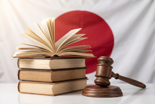 日本国旗を背景にした法律書と木槌 日本の司法制度と法律のイメージ