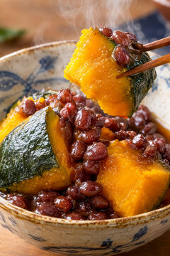 冬至の日に食べる湯気が立ち上るお箸で持ち上げた温かいかぼちゃのいとこ煮４