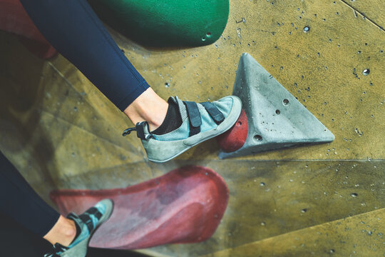 Teal Climbing Shoes Stepping on Bouldering Wall Holds