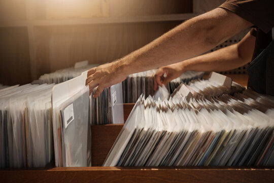 Vinyl Record Shopping in Music Store, Collector Browsing Retro Albums and Sleeves.