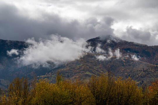 Low clouds over mountains and autumn trees