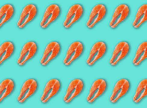 Raw fresh salmon steaks in rows on turquoise background