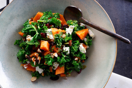 Baked sweet potato and kale salad with goat cheese and dried fruit