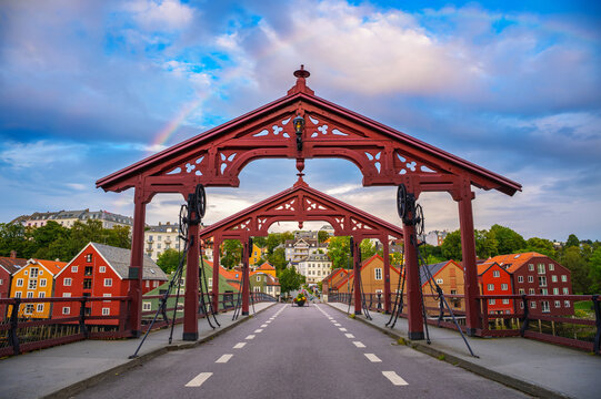 Historic Old Town Bridge spans the Nidelva River in Trondheim, Norway, framed by colorful wooden houses and a rainbow.