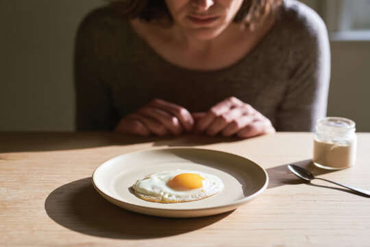 A minimalist approach to breakfast showcases a simple fried egg on a plain plate, highlighting the beauty of simplicity and nourishment in everyday meals.