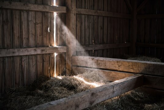 Interior of an old alpine hay barn with a shaft of morning light through wooden boards