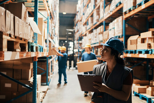 Female warehouse worker checking inventory with clipboard